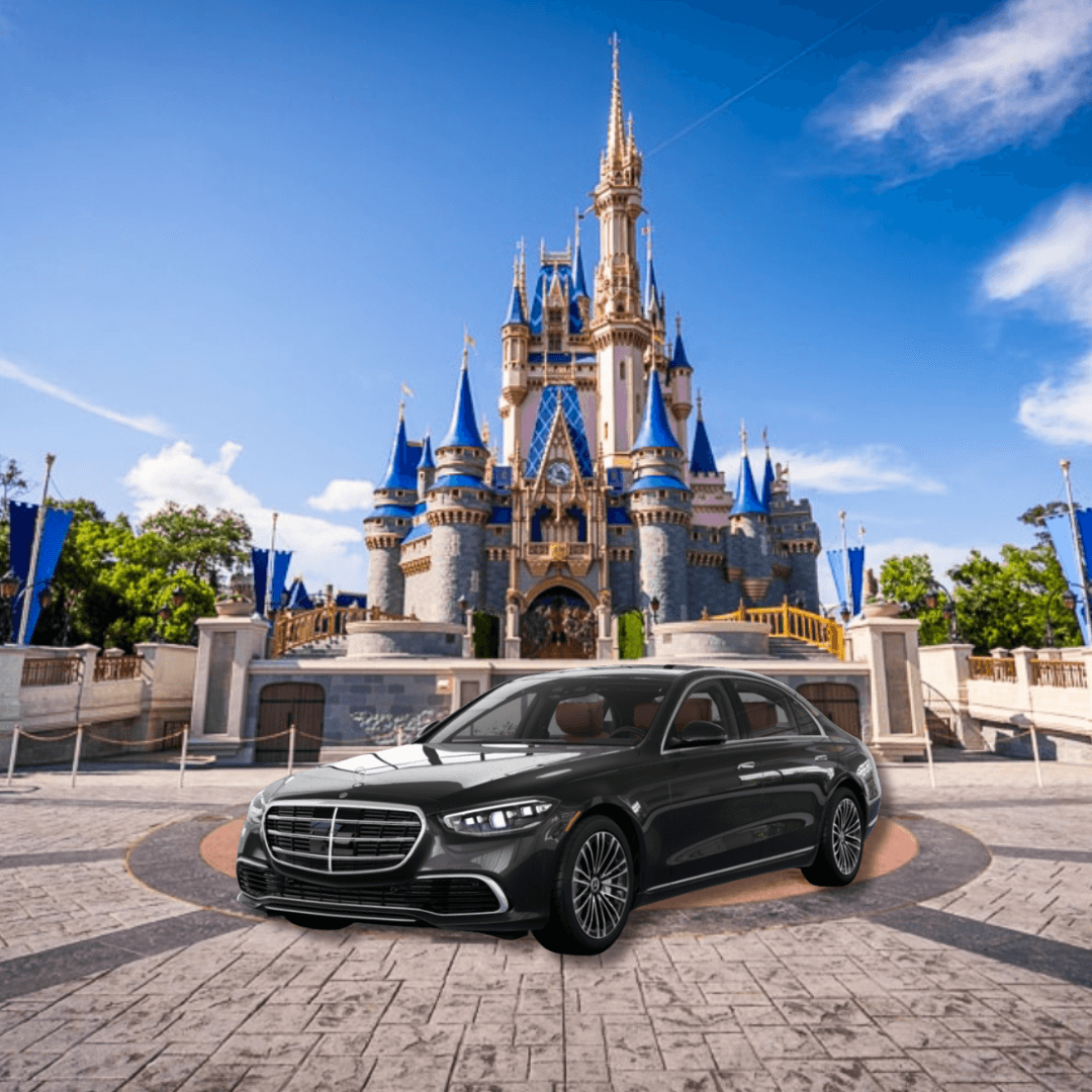 Luxury black car parked in front of a grand castle under blue sky.